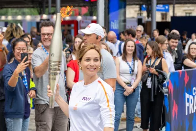 Nathalie Péchalat portant la flamme devant le Club France. 